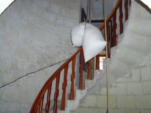 14 - the sack with grain being lifted to the grinding stone on top